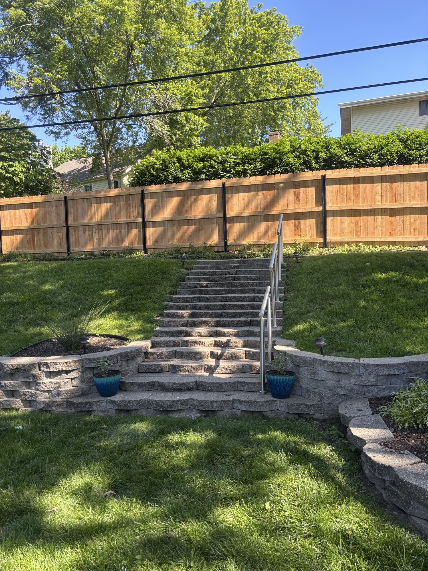 Stone retaining wall with steps and cedar fence, Greater St. Louis